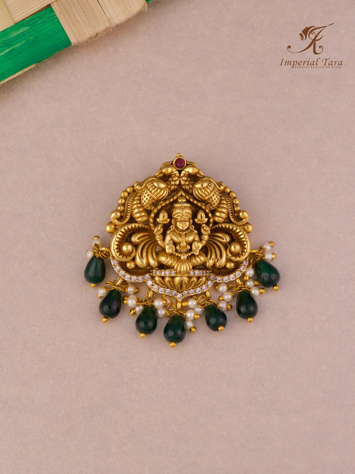Detail view of gold finish Lakshmi pendant with green beads